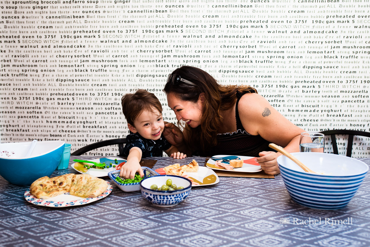 mother and son giggle over lunch at the kitchen table London family portrait