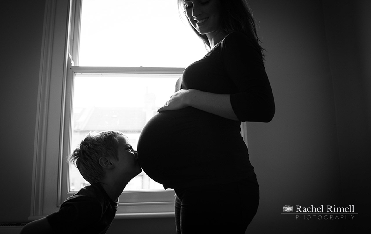 Mother and child photo session - child kissing bump