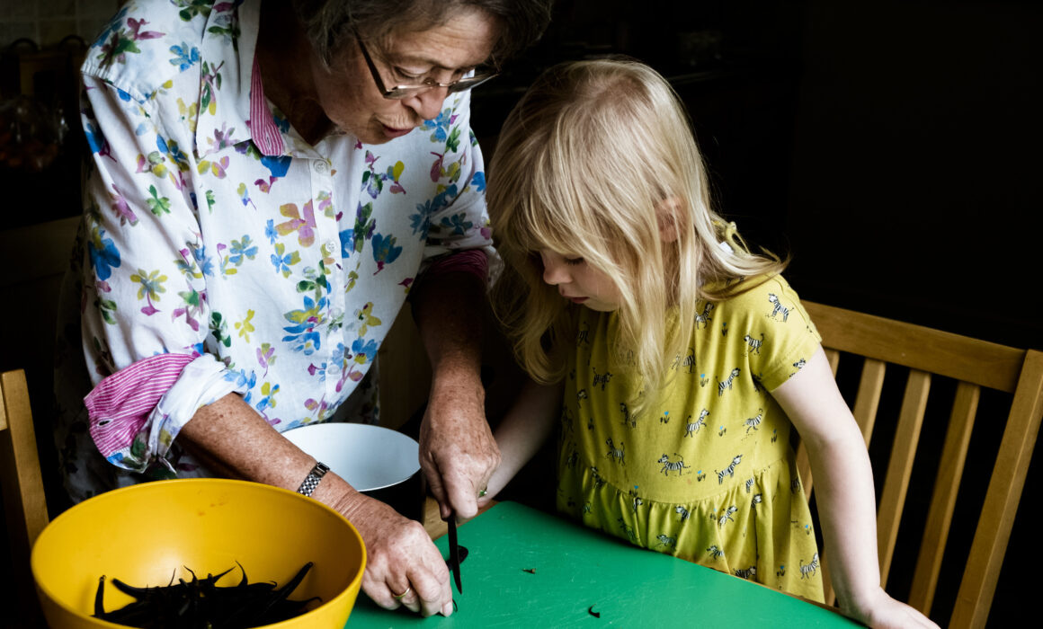 Grandmother and granddaughter chopping beans in the kitchen together day in the life photographer