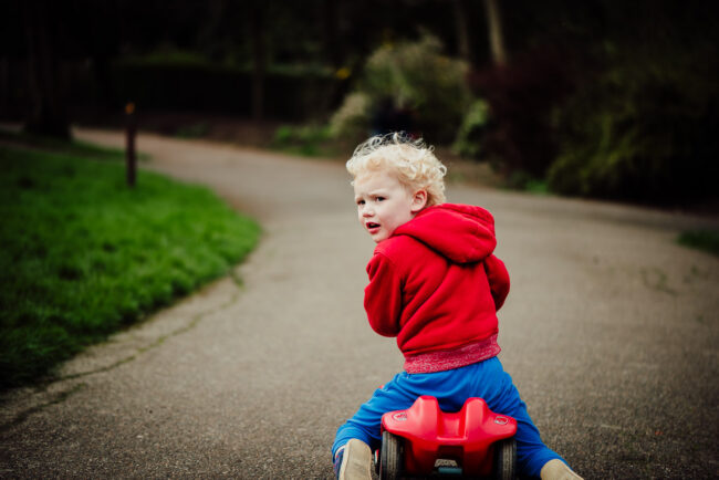 natural portrait of boy in red on ride in car London park