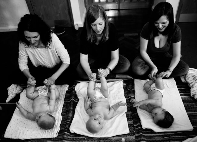 Three mums with three babies at baby massage class, black and white business editorial photograph for Sensoryland, Streatham, London