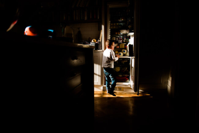 day in the life family photography session boy stealing food from the fridge