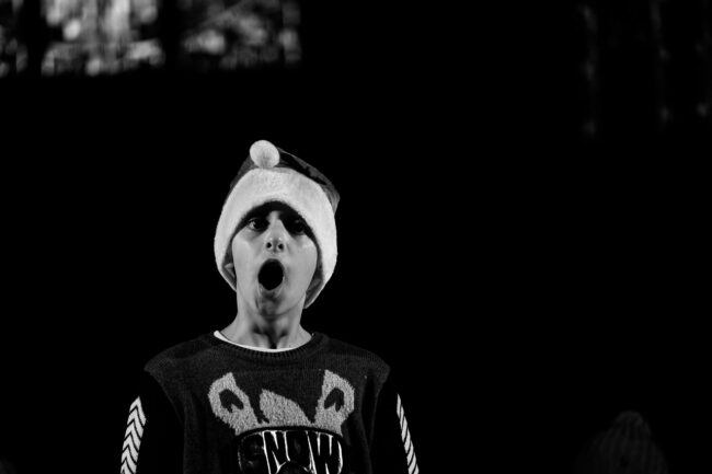 Event photo of chorister singing with santa hat at performance of The Snowman for Sydenham Arts