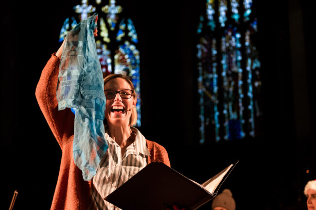 Sydenham Arts performance of The Snowman photo of narrator holding up blue scarf