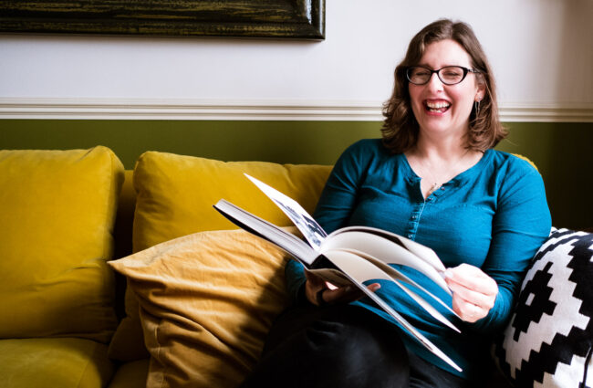 personal branding portrait of Anna Hindocha casual photo reading on the sofa and laughing