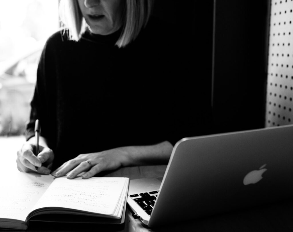 London personal branding photo of life coach at work in a cafe with laptop open and writing in her notebook, London, Crystal Palace