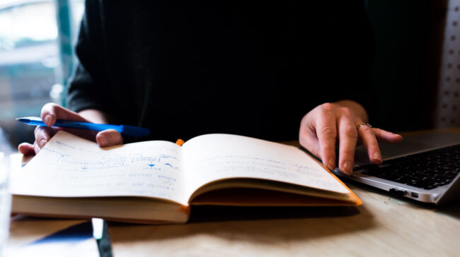 close up detail of notebook and hands with pen as part of a professional personal branding photography session in south London