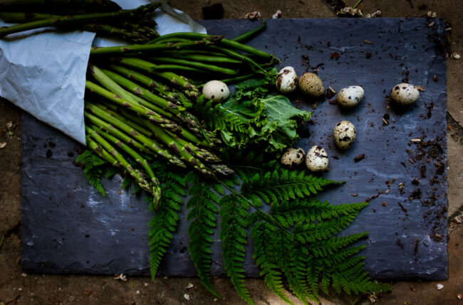 flat lay of asparagus, kale, green beans and quails eggs on a slate and rustic background, London food photo