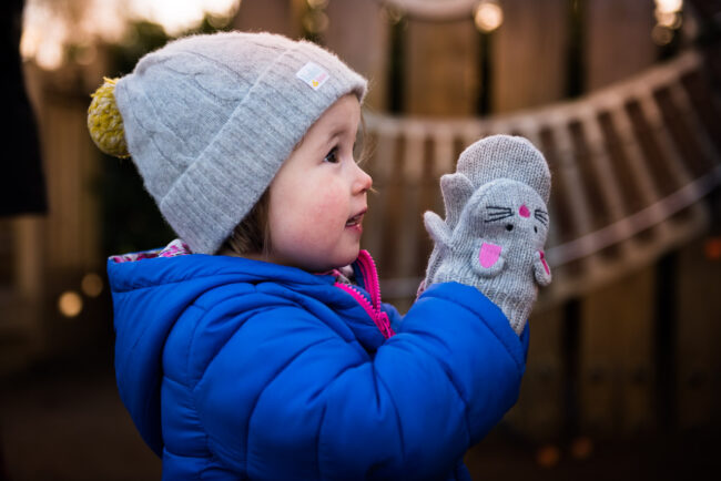 candid portrait of girl in grey hat and mouse mittens on relaxed natural family photography session in London