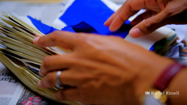 detail of textile arist flicking through fabric sample book