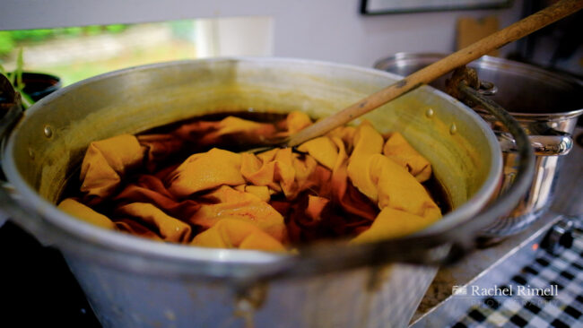 detail of natural dying process with yellow cloth in onion skin dye by London textile artists for editorial photography session