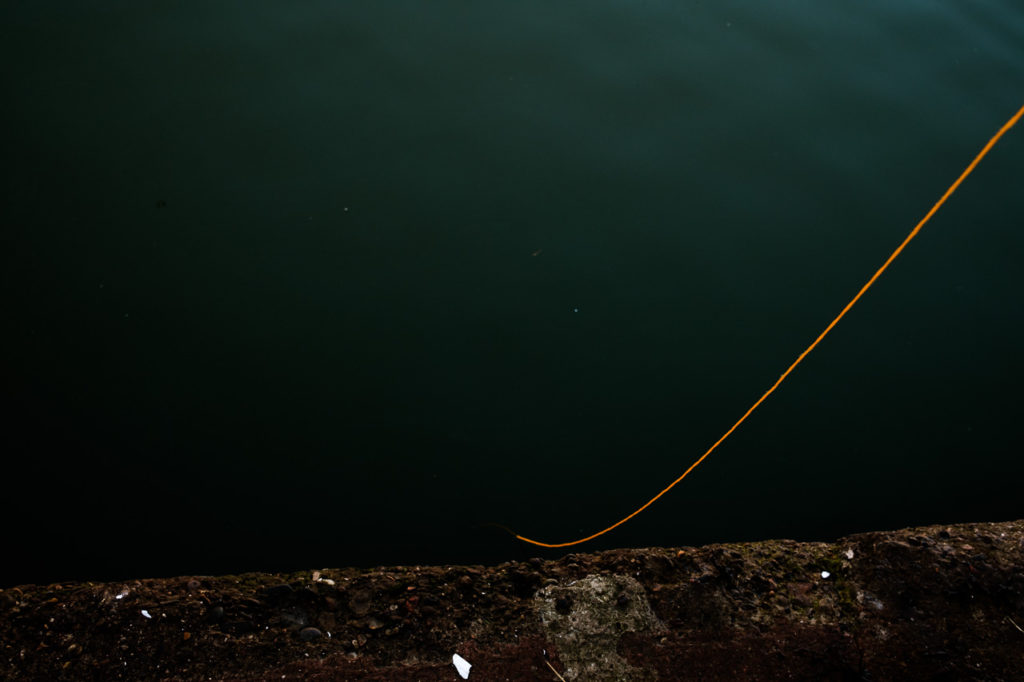 Orange fishing line descending into the sea at Whitby off the jetty