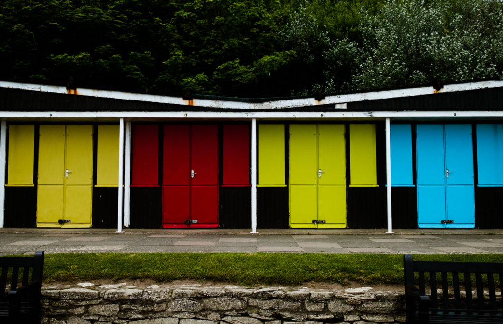 closed up beach huts in red, yellow and blue at Filey sea front North Yorkshire