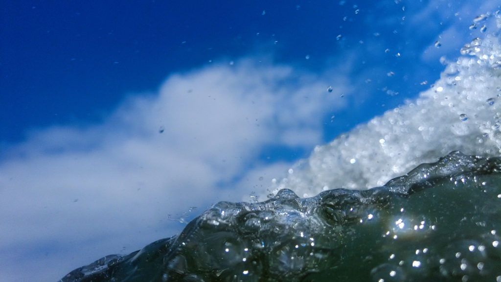 immersed water of a wave rolling over the camera