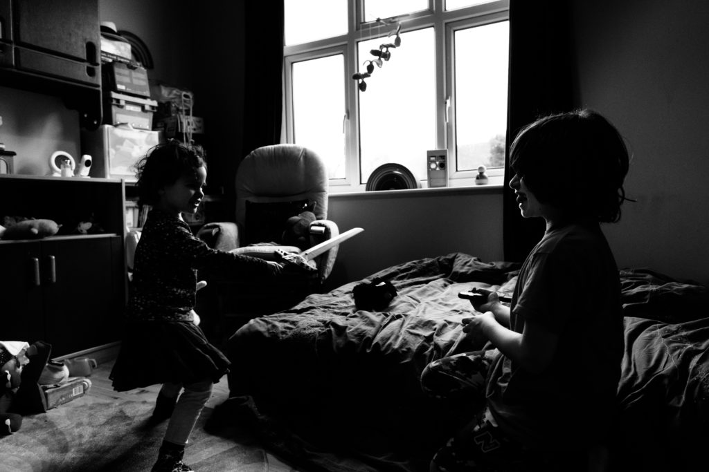 two children play fighting in their bedroom natural documentary style family photography Yorkshire