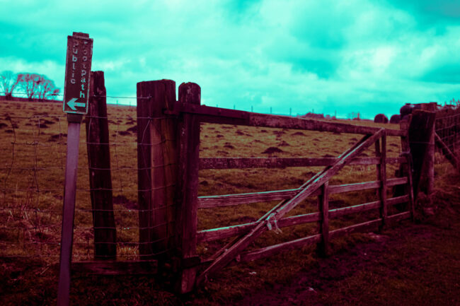 Photographic work exploring trespass and right to roam North Yorkshire. Image of a gate with public right of way sign in unnatural colours