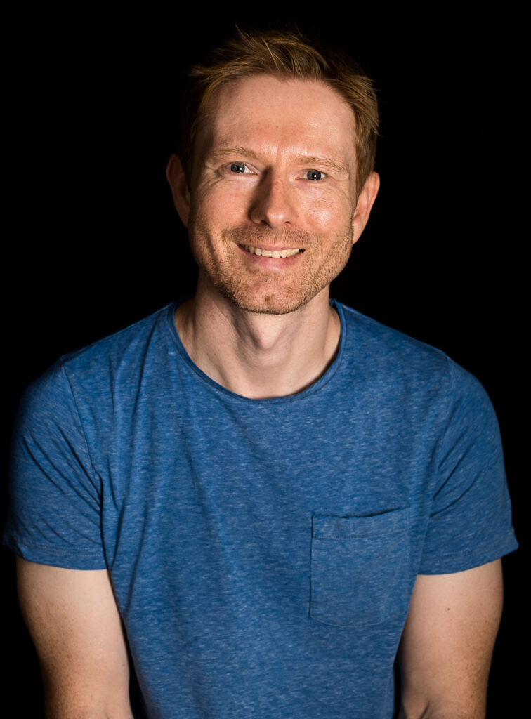 headshot of white man with auburn hair in a blue t-shirt in a north yorkshire photography studio