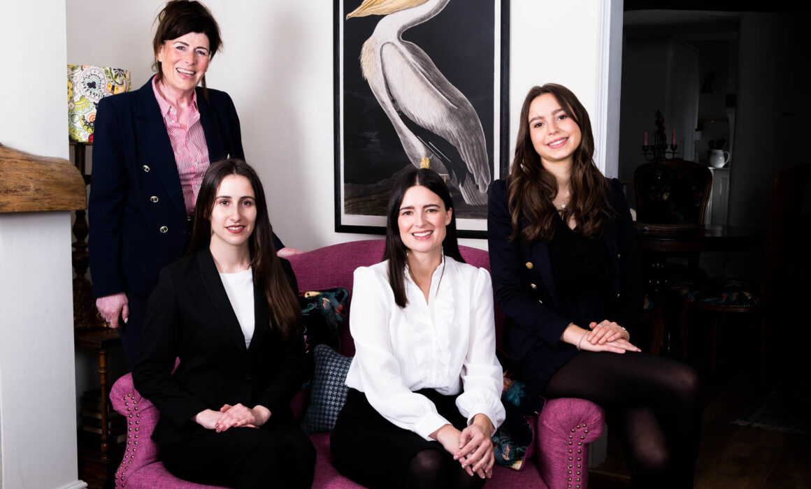 4 women on sofa for professional team photo pink sofa